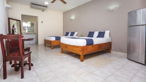 A bedroom with two wooden beds, a ceiling fan, an air conditioner, and a refrigerator. - Hotel Kiin Cozumel (Cozumel)