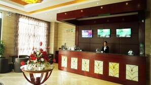 A hotel reception area with a wooden reception desk, a large chandelier, and three flat-screen TVs mounted on the wall. - Greentree Inn Luoyang Yichuan Yilong Avenue (Luoyang)