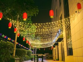Un espacio al aire libre con luces colgantes y faroles rojos.