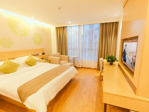 A hotel room with a large bed, a desk, a chair, and a television. - Greentree Inn Haining Chang an University Town (Jiaxing)