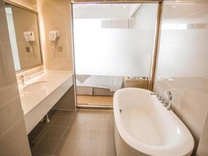 A modern bathroom with a large bathtub, a shower enclosure, and a vanity with a mirror. - Greentree Inn Suqian Suyu District Red Star Macall (Suqian)