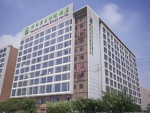 A multi-story building with a grid of windows and a sign with Chinese characters.