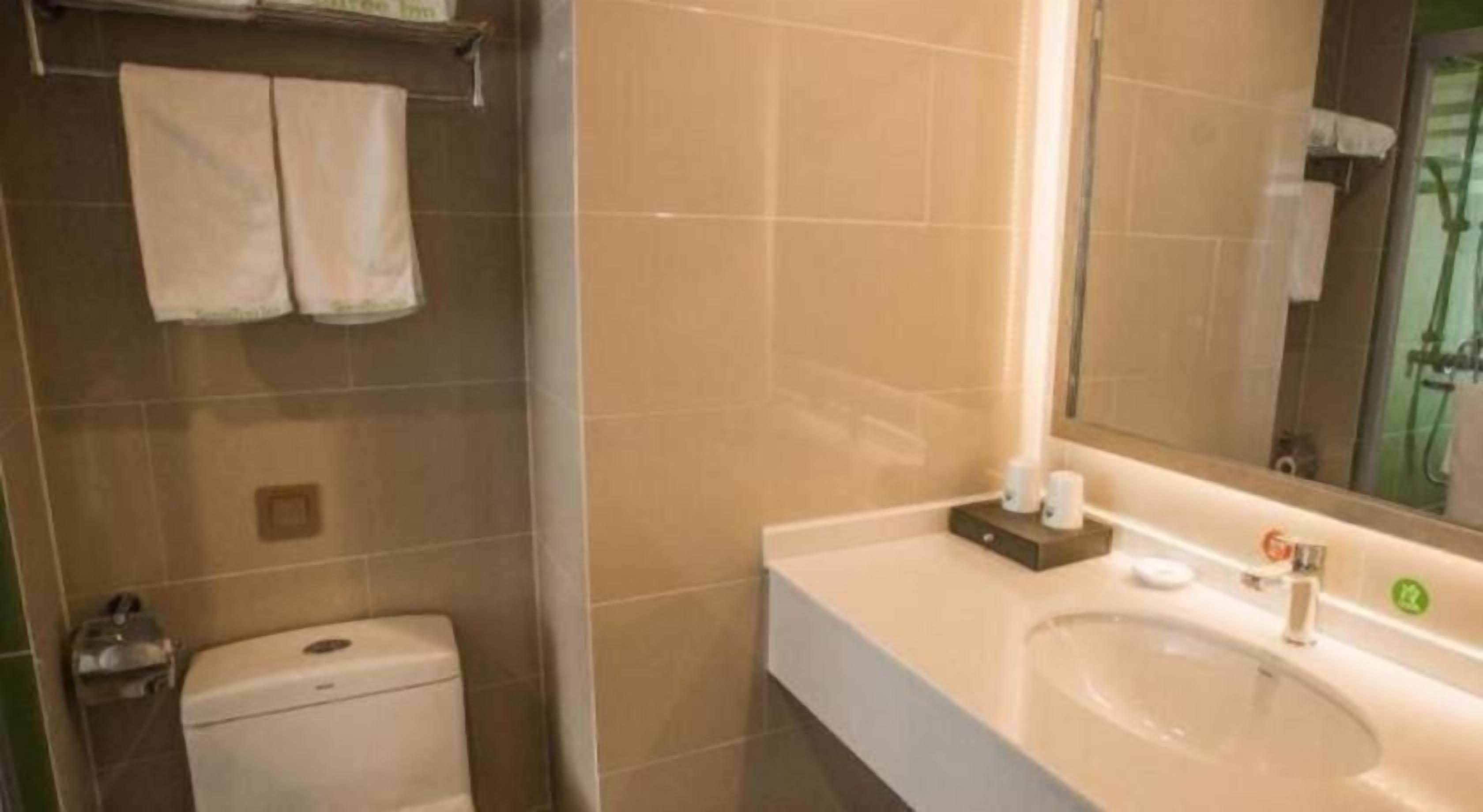 Une salle de bain avec des toilettes, un lavabo et un miroir.