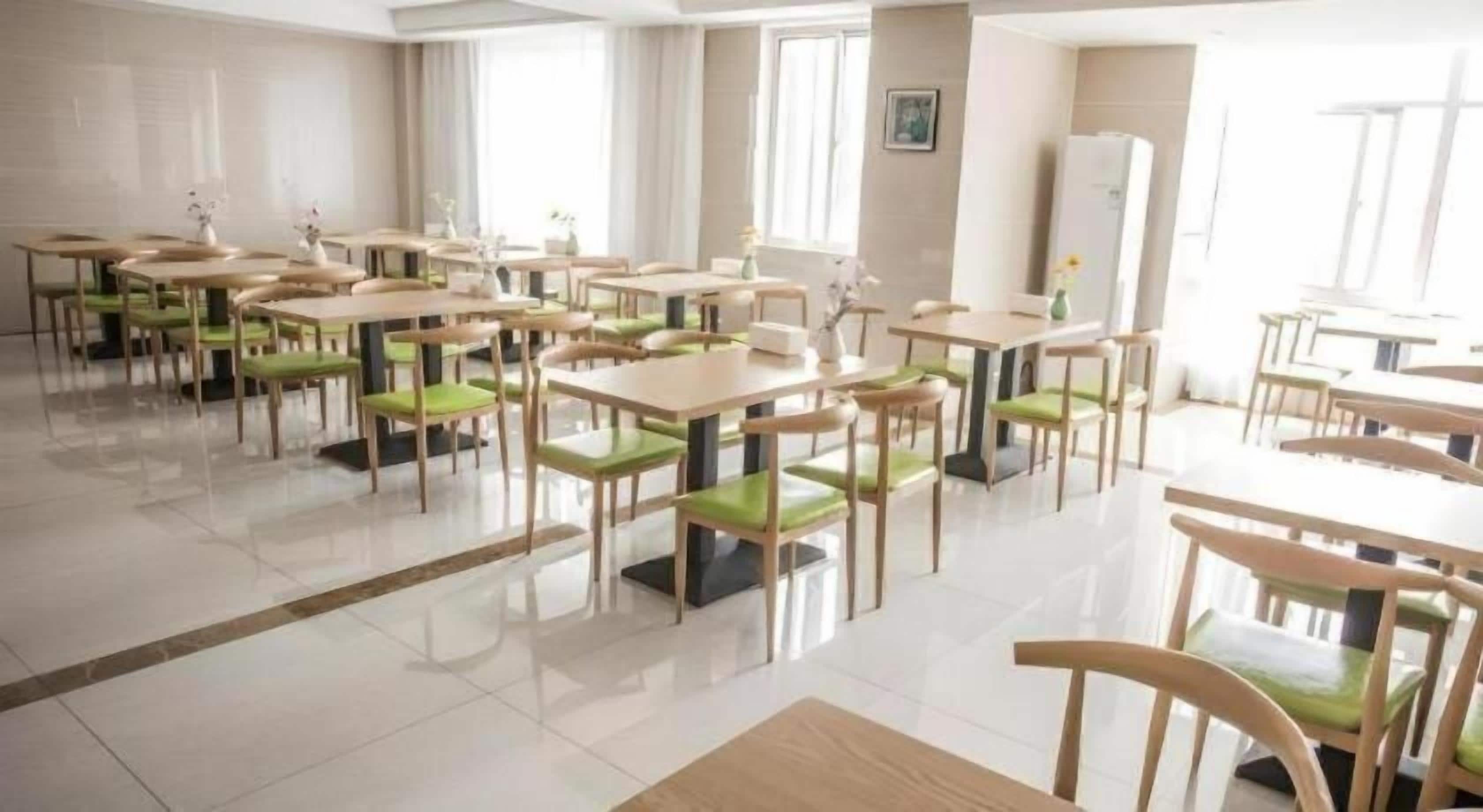 A spacious dining area with multiple tables and chairs, arranged in a grid pattern.