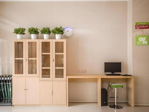 A room with a wooden cabinet with glass doors, a desk with a computer, and a green stool. - Greentree Inn Suqian Suyu District Red Star Macall (Suqian)
