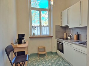 Une cuisine de taille réduite, dotée d’une fenêtre, d’une machine à café, d’un évier et d’une cuisinière.