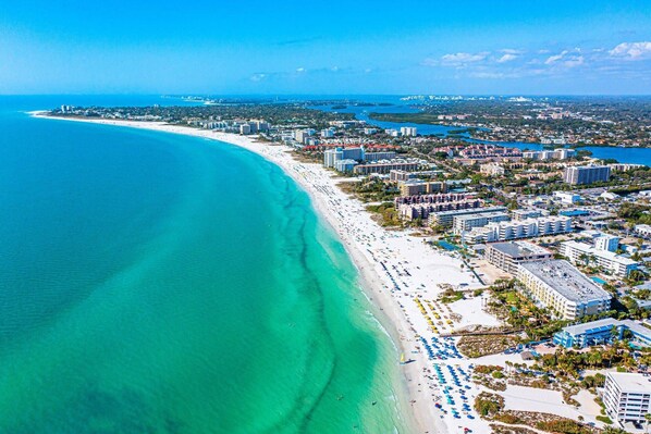 Enjoy sunbathing and relaxation on the long, sandy beach adjacent to the clear blue ocean.