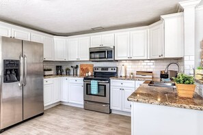 Enjoy cooking in this well-equipped kitchen with a water dispenser, coffee maker, and stainless steel appliances.