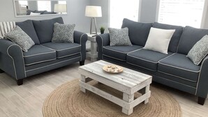 A living room with two grey sofas, a white coffee table, and a woven rug. - Close to Beach & Shops | Private Home | Dog OK | Outdoor Seating | 1/2 mile to Siesta Key Bridge (Sarasota)