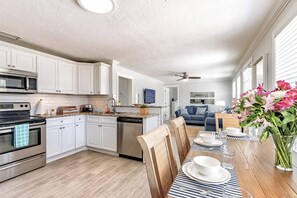 Enjoy meals in the well-equipped kitchen with a dining area for two, featuring a microwave, toaster, and dishwasher.