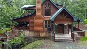 A log cabin with a porch, a chimney, and a stone foundation. - Safe Haven- Mountain View-hot tub-wifi- pool table (Morganton)