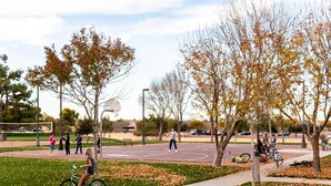 A park with a basketball court, trees, and people. - Cute, Clean & Comfortable in the Best Community! (Gilbert)