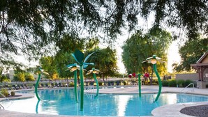 A swimming pool with green decorative elements and lounge chairs. - Cute, Clean & Comfortable in the Best Community! (Gilbert)
