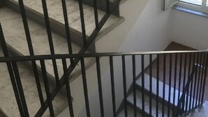 Una scala con ringhiere nere e gradini in marmo.
