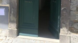 Una porta verde con sommità ad arco che dà su un edificio.