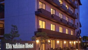 A multi-story hotel with a modern design, featuring balconies on each floor and a well-lit exterior. - Enoshima Hotel (Fujisawa)