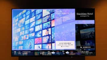 A television screen displaying a hotel interface with multiple room options, weather information, and a VOD service advertisement.