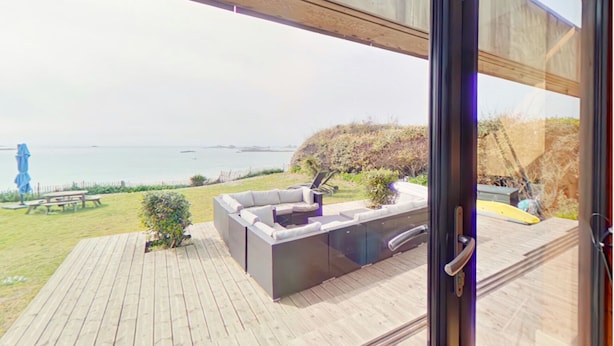 A modern outdoor patio with a built-in seating area overlooking a coastal landscape.
