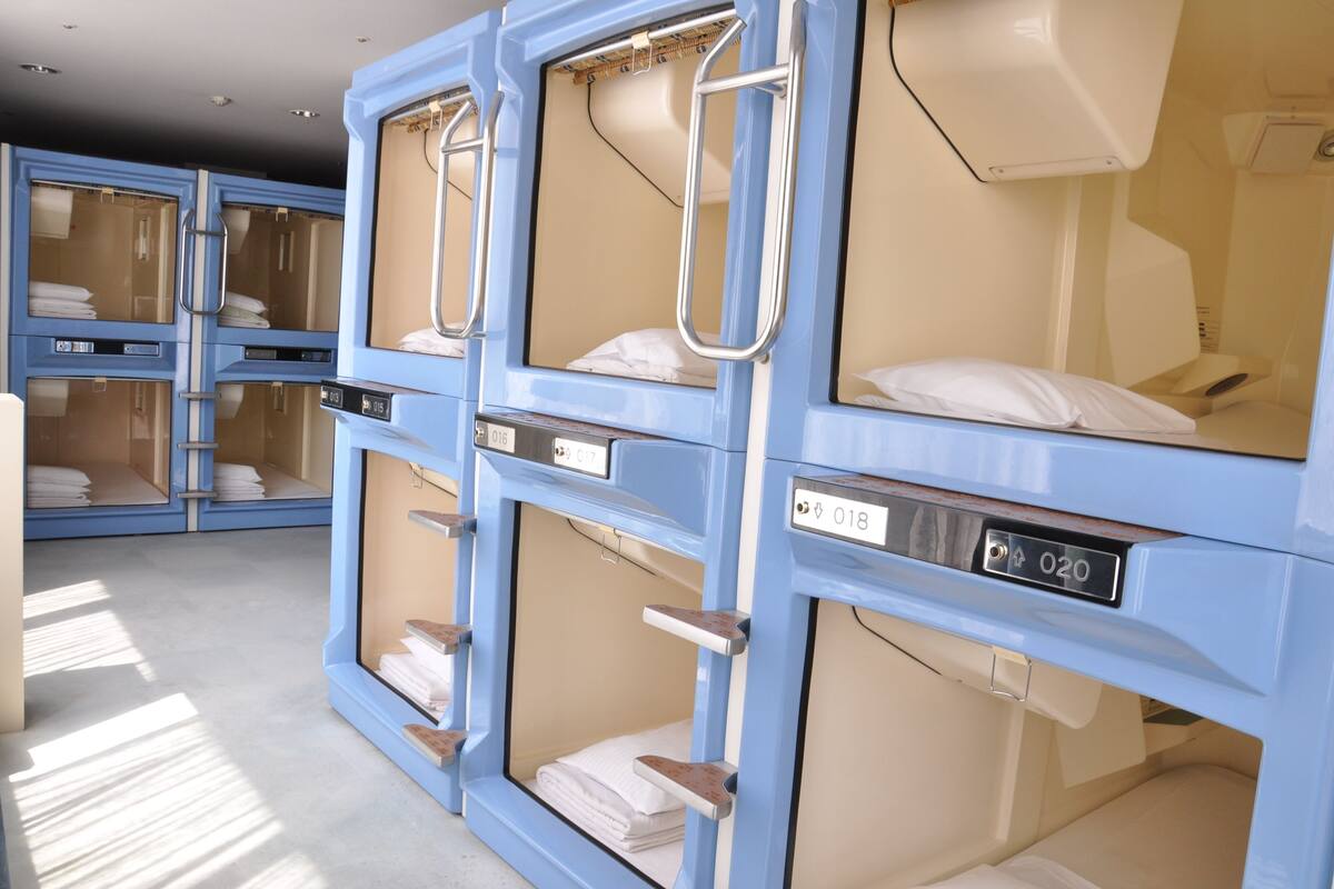 A row of blue single rooms with individual beds, each with a number label.