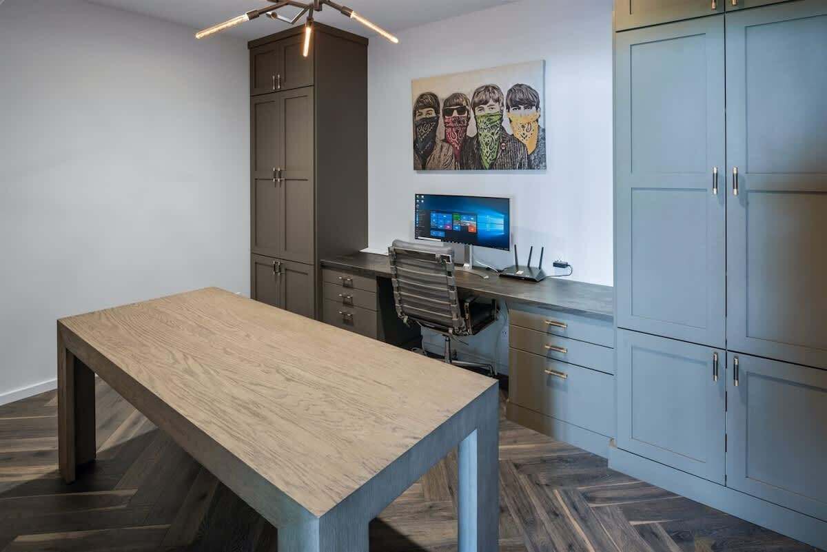 A modern office space with a desk, computer, and storage cabinets.