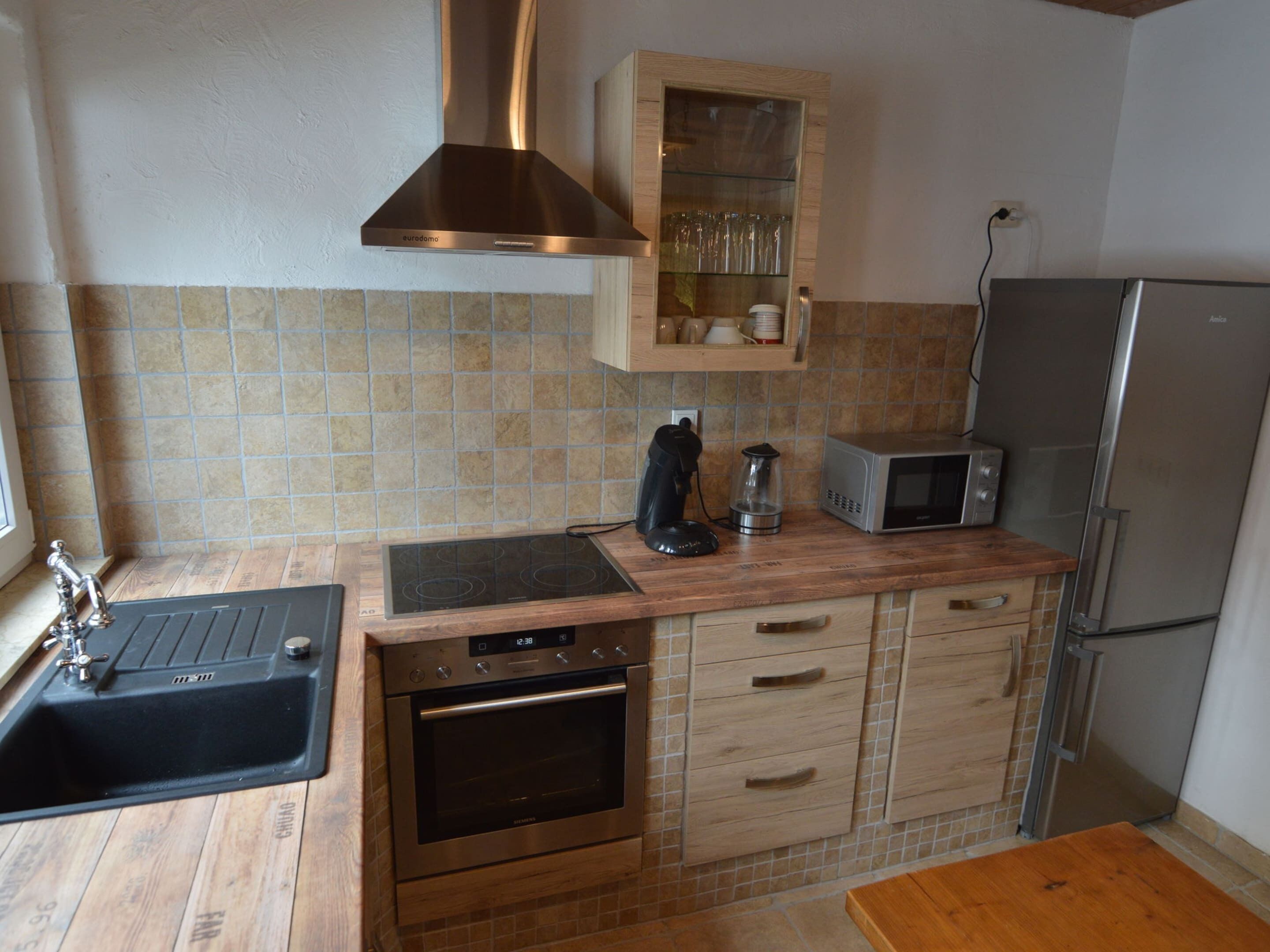 A compact kitchen with a built-in stove, oven, and microwave.