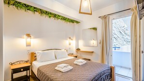 Een slaapkamer met een bed, nachtkastjes, een spiegel en uitzicht op een balkon.
