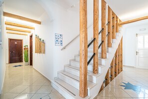 A staircase with wooden handrails and a sign indicating room numbers. - Marianna Hotel (Santorini)