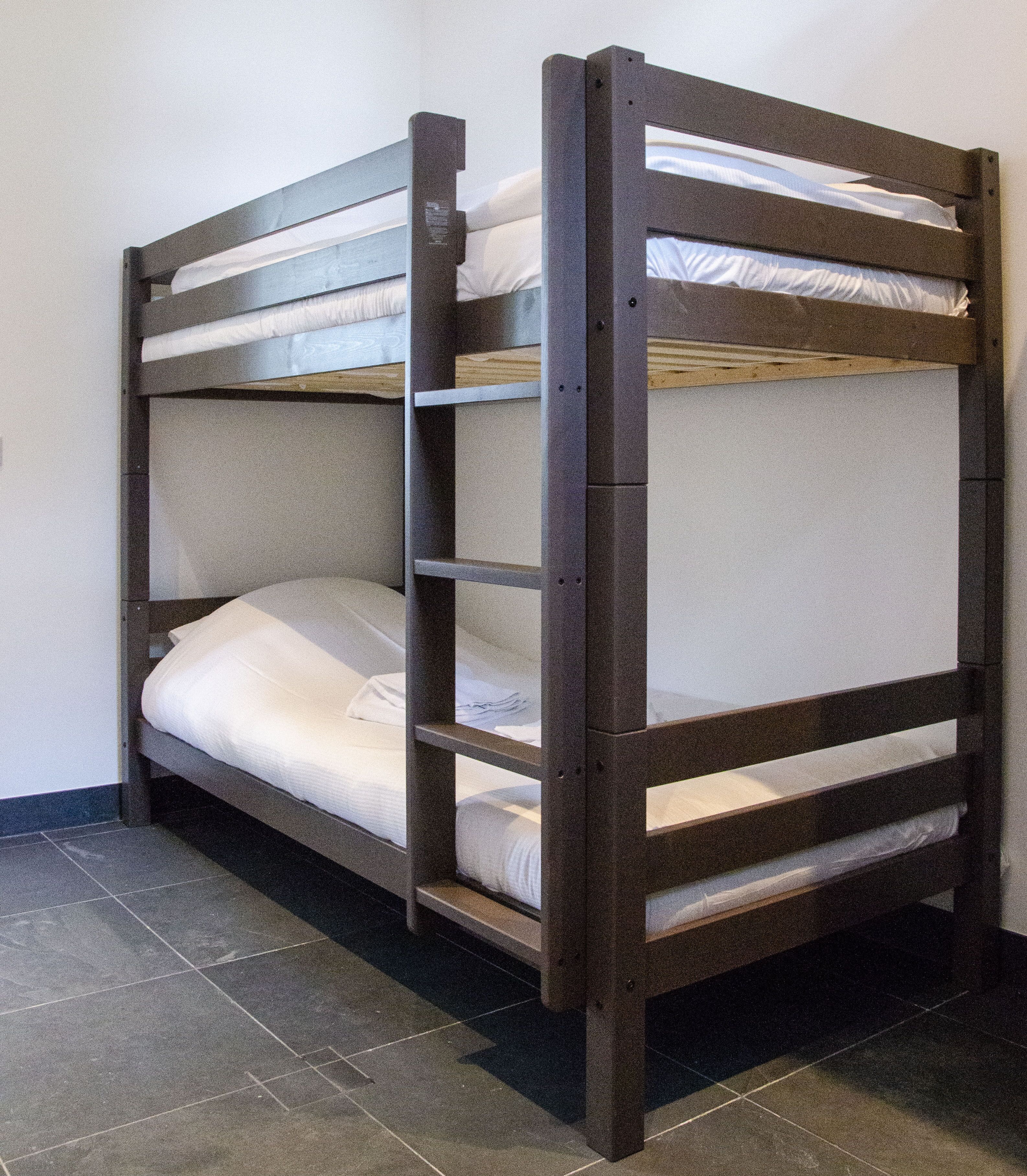 Ein Etagenbett mit zwei Schlafstellen, jeweils mit Matratze und Kissen.