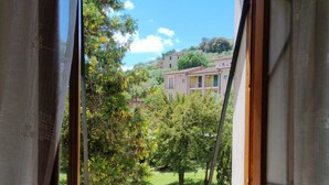 A window with a view of a green lawn and buildings in the distance. - VILLA LA PINETA DI SINALUNGA - Valdichiana and Val d'Orcia for family or friends (SINALUNGA)