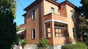 A two-story brick house with a balcony, a satellite dish, and potted plants. - VILLA LA PINETA DI SINALUNGA - Valdichiana and Val d'Orcia for family or friends (SINALUNGA)