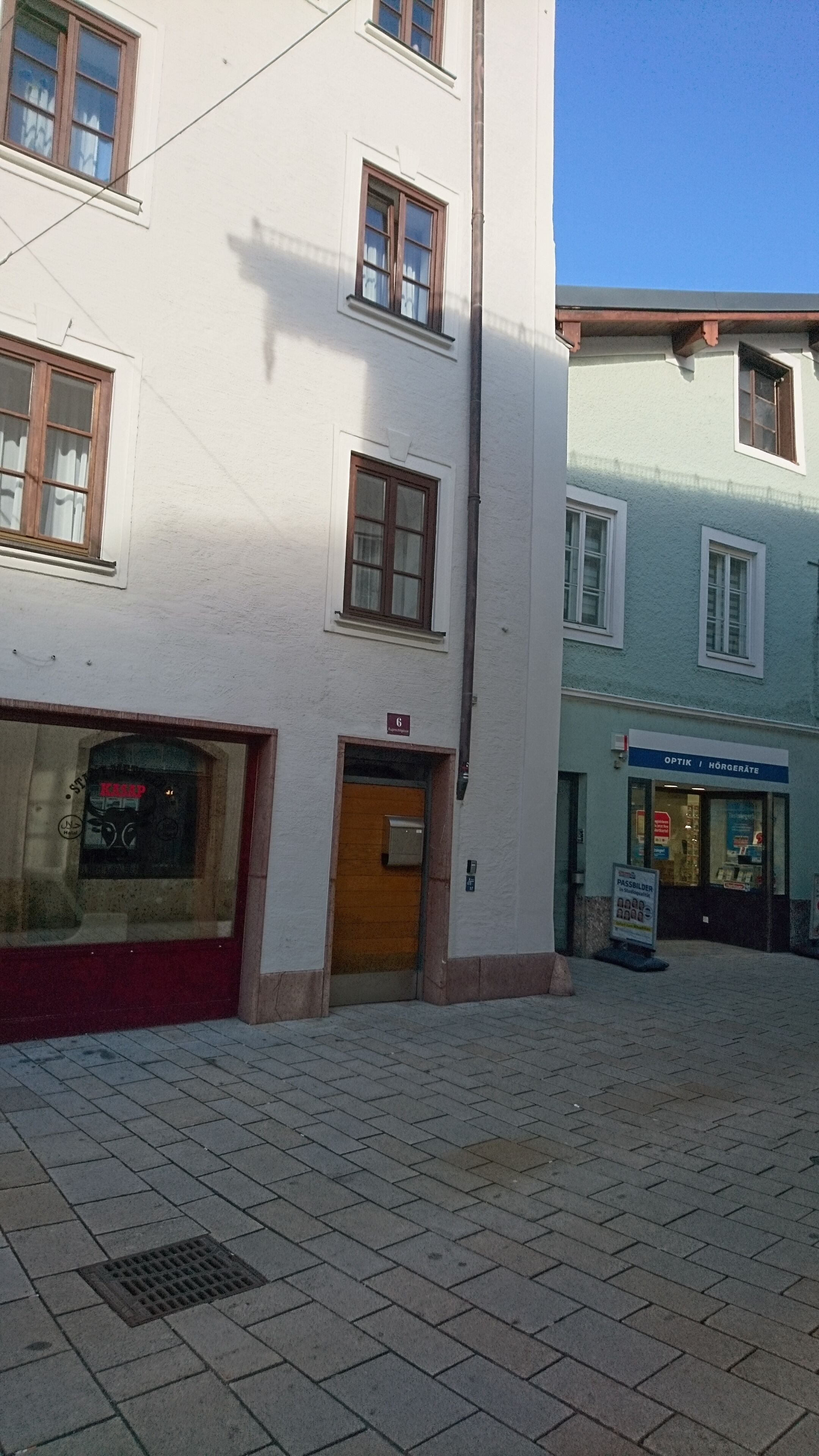 Un edificio con entrada a nivel de calle, una puerta visible y una ventana con un letrero encima.