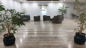 A modern lobby with a 'TARIK' sign, wicker furniture, and potted plants. - Tarik  by Atlantichotels (Portimão)