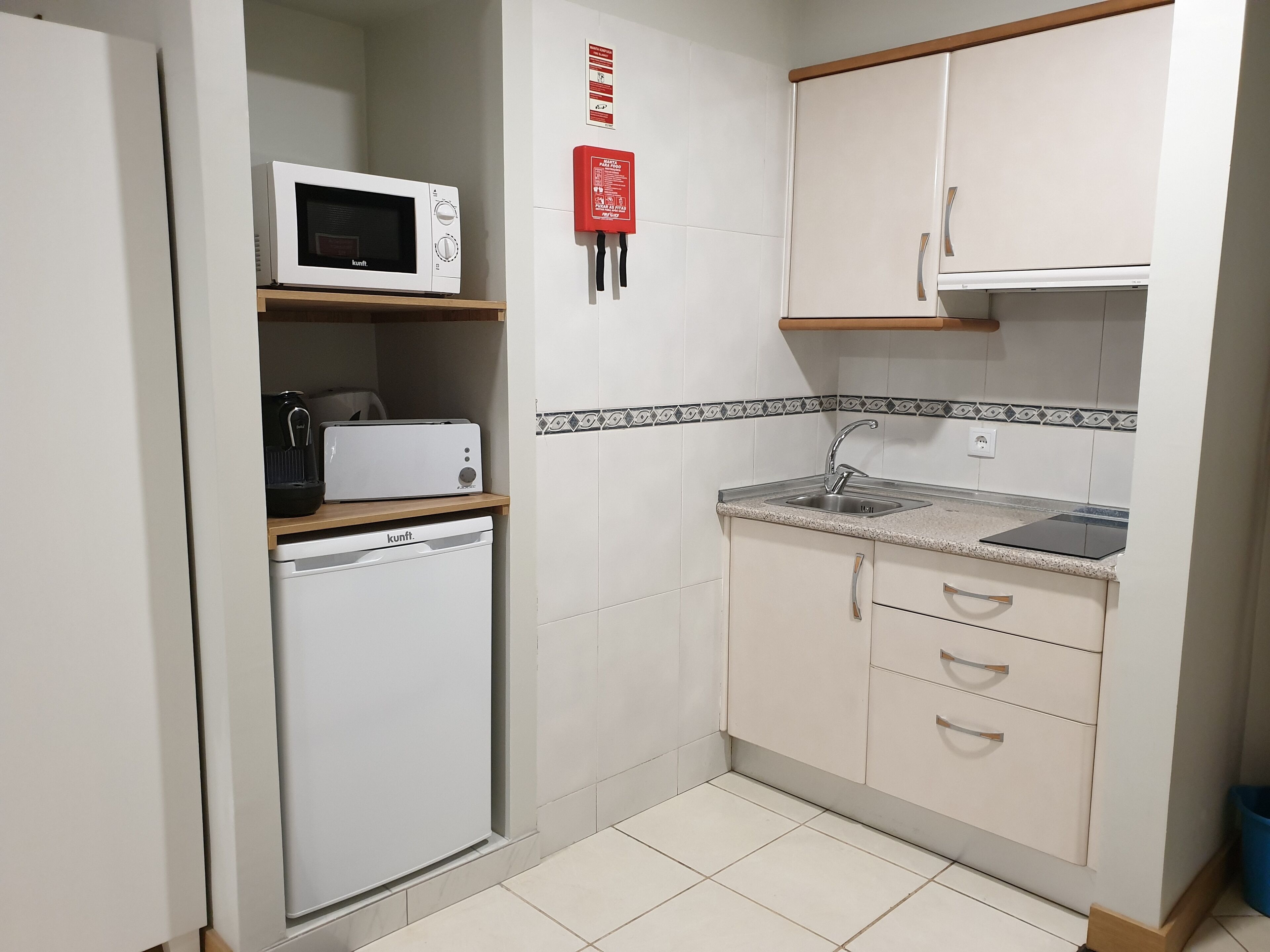 A compact kitchen with a microwave, toaster, and dishwasher.