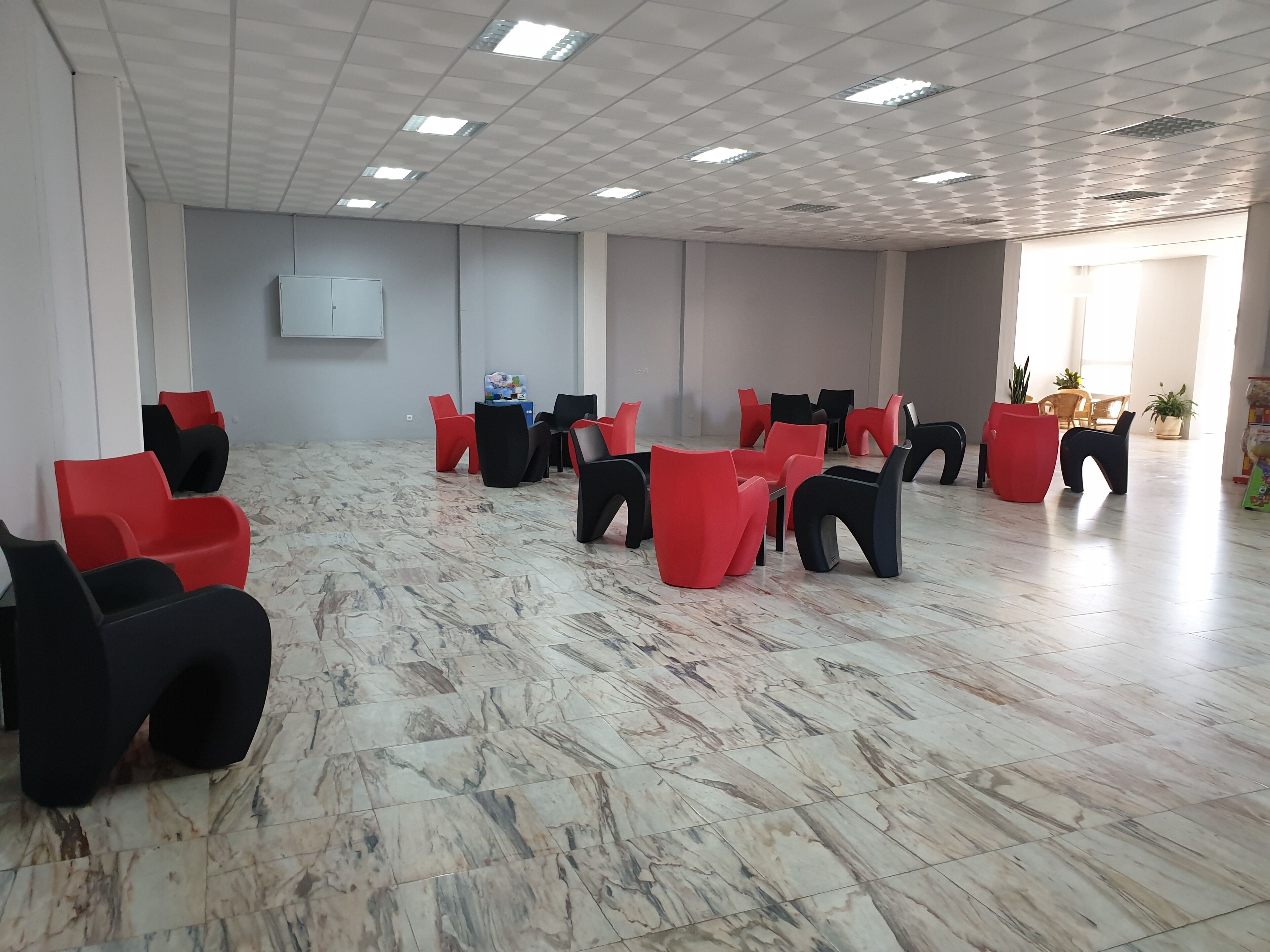 A spacious room with a marble floor and a ceiling with recessed lighting.