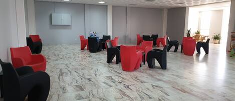 A spacious room with a marble floor and a ceiling with recessed lighting.