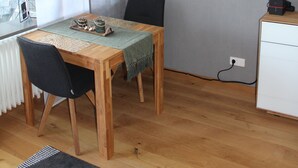 Un comedor con una mesa de madera, sillas y una lámpara colgante.