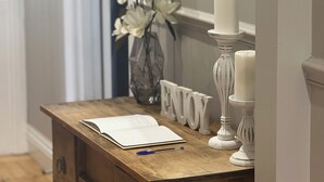 A wooden desk with a book, a pen, and a vase of flowers. - Skibo Cottage (Skibo)