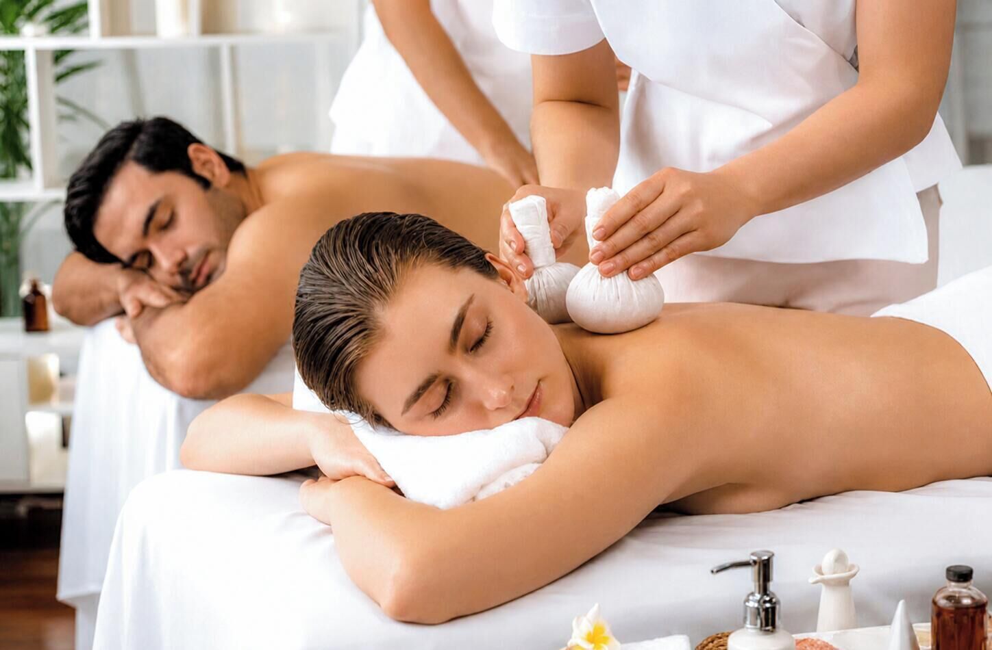 A massage therapy session in a spa setting with a massage table, towels, and various spa products.