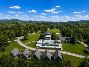 A golf course with a clubhouse, multiple buildings, and a large swimming pool. - SKYLARANNA Resort & Spa (Hendersonville)