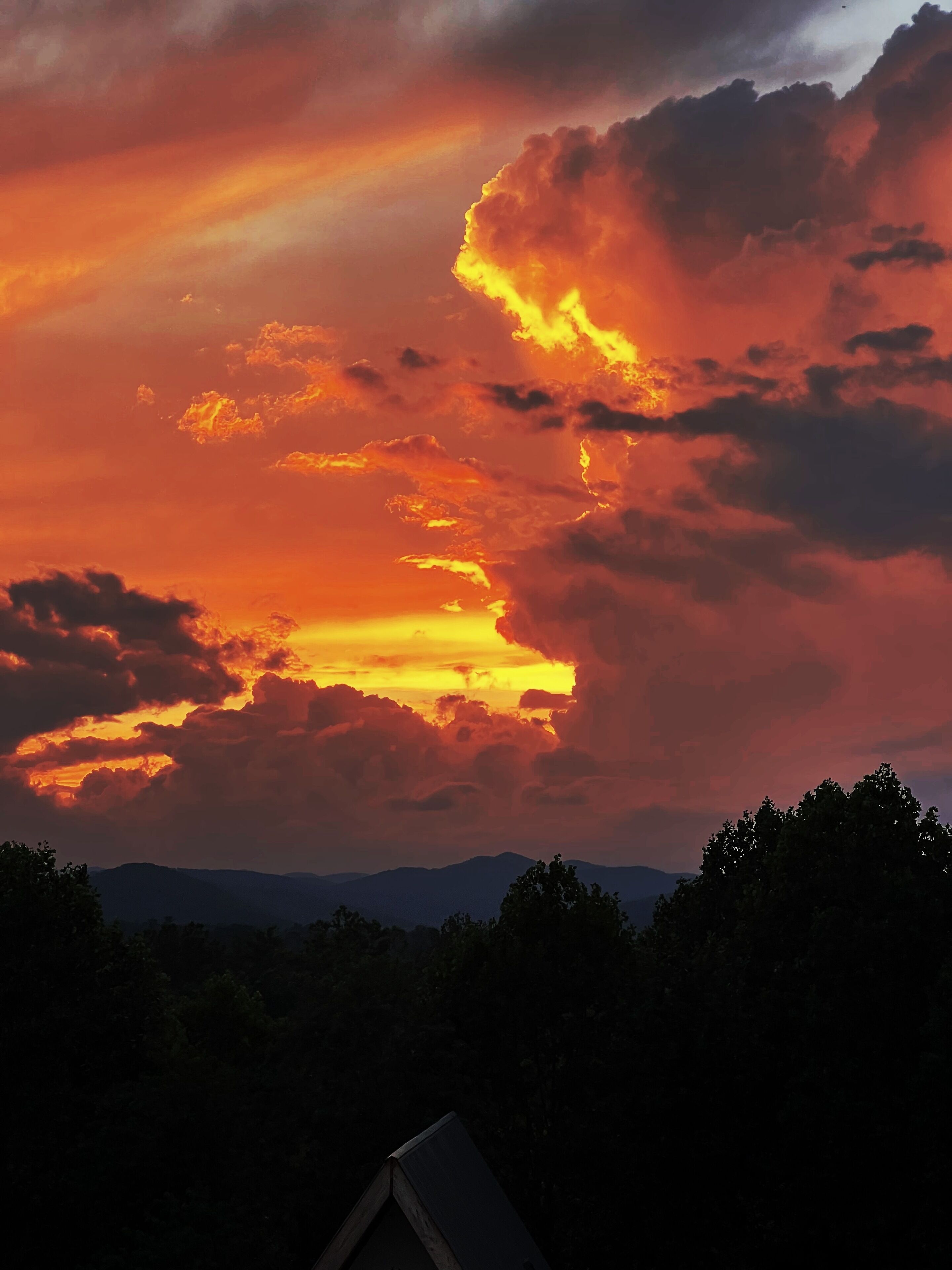 Een zonsondergang met wolken boven een bergketen.