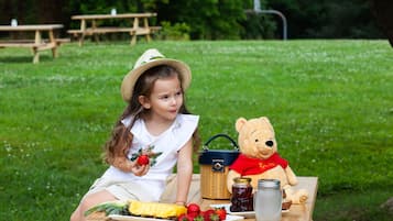 Enjoy a casual outdoor dining experience with a picnic setup amidst lush greenery.