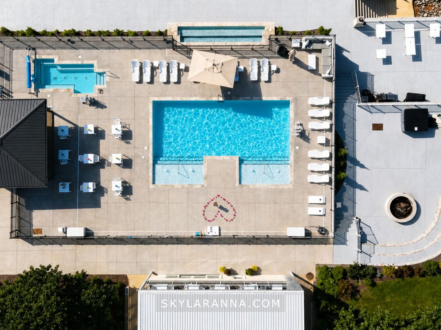 Una piscina al aire libre, sombrillas, sillones reclinables de piscina