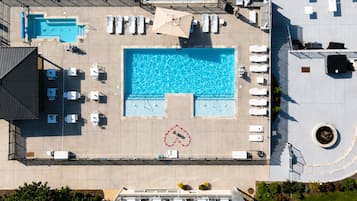Una piscina al aire libre, sombrillas, sillones reclinables de piscina