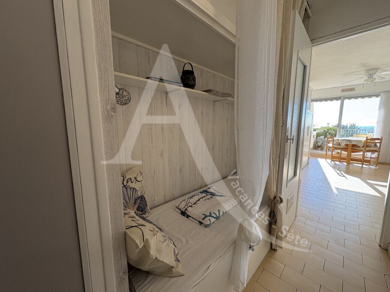 Quarto com cama, mesa de cabeceira e janela.