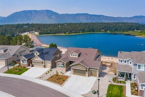 A residential area with houses, a lake, and mountains in the background.