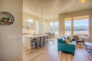 A spacious living area with a sofa, a dining table, and a kitchen with a bar.
