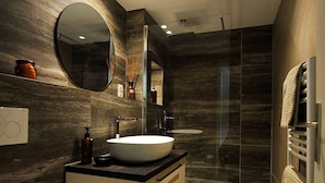 A modern bathroom with a large oval sink, a toilet, and a glass-enclosed shower. - Apartment facing the beach (Cannes)