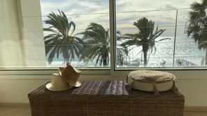 A wicker bench with a woven seat and backrest, a woven pouf, and a straw hat. - Apartment facing the beach (Cannes)