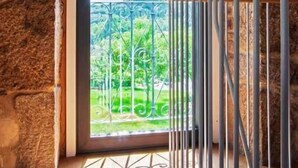 Une pièce avec un mur en pierre, une porte en bois et une rambarde en métal.