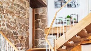 A wooden staircase with stone walls and a wooden floor. - A Forxa - Casa Ferrador (Ribeira Sacra) (Bolmente)